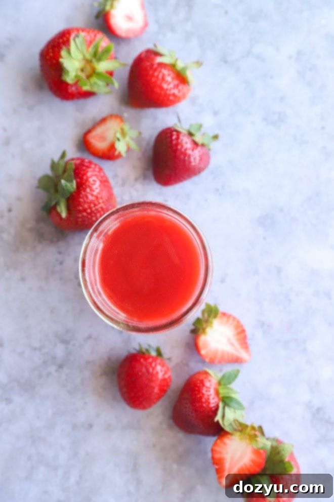 Overhead image of strawberry coulis in mason jar