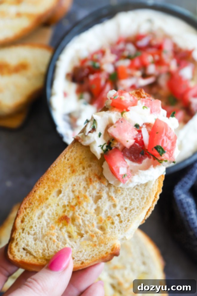 A toasted bread slice topped with a generous amount of whipped goat cheese salsa dip