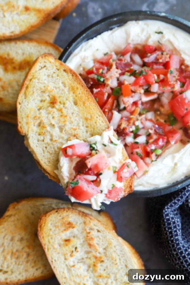 A beautifully presented bowl of whipped goat cheese salsa dip with dippers, ready for a party