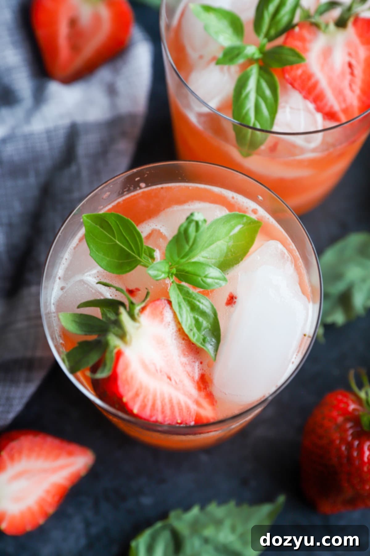 A vibrant Strawberry Basil Margarita in a glass with a strawberry and basil garnish