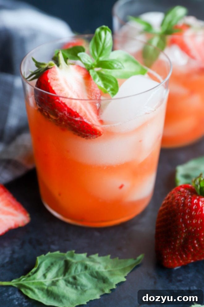 Close-up of a Strawberry Basil Margarita garnished with a strawberry slice and basil leaf