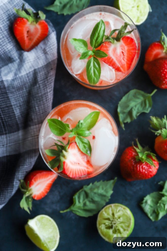 Pouring a Strawberry Basil Margarita into a glass with ice and garnish