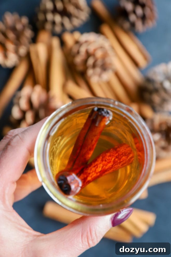 Cinnamon Simple Syrup with a whiskey glass and cocktail ingredients, setting a scene for fall cocktails.