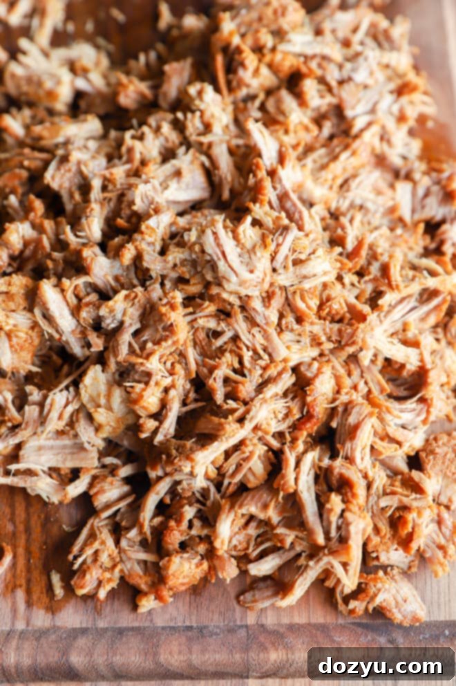 Freshly shredded pork on a wooden cutting board