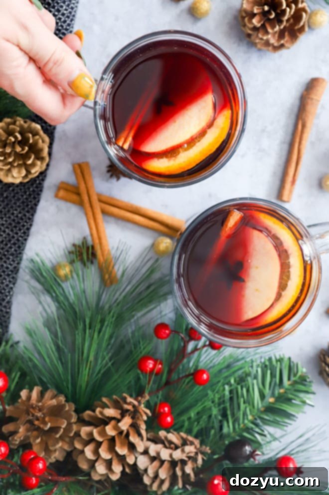 Hand holding a mug of mulled wine in clear glass