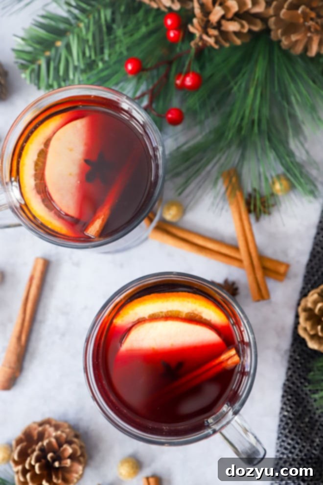 Clear mugs of warm red wine with mulling spices