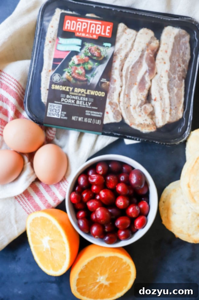 A collection of ingredients for the pork belly breakfast sandwich, including AdapTable pork belly, eggs, cranberries, and biscuits.