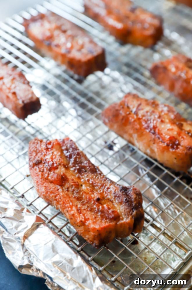Oven-roasted AdapTable Smokey Applewood Boneless Pork Belly, golden and tender, still on the baking rack.