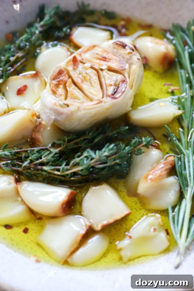 Air fryer roasted garlic cloves in a small bowl with a hint of olive oil.