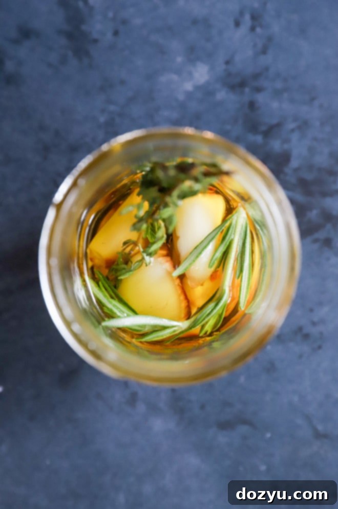 Garlic-infused olive oil with chili flakes and herbs in a small glass jar.