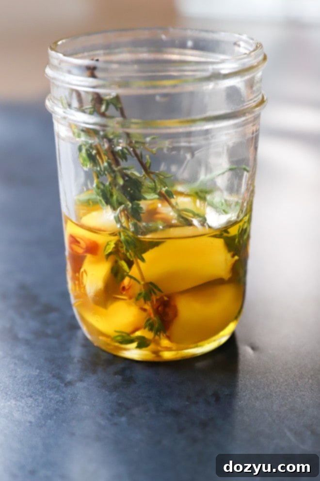 Picture of oil with garlic herbs and chili pepper flakes, ready for roasting.