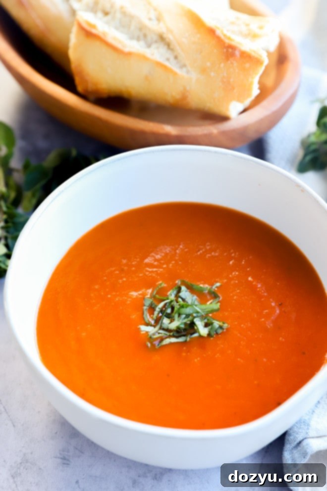 Easy Instant Pot Tomato Soup 8 Bowl of tomato soup with basil and bread image