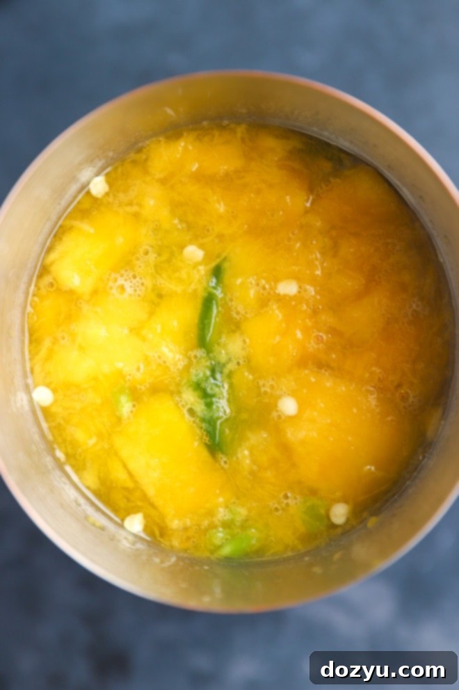 Muddled mango and jalapeño mixture in a cocktail shaker