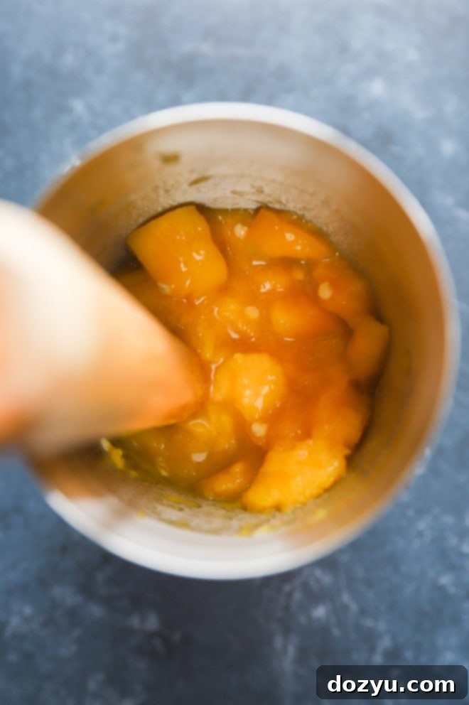 Mango muddled in cocktail shaker with jalapeño slices