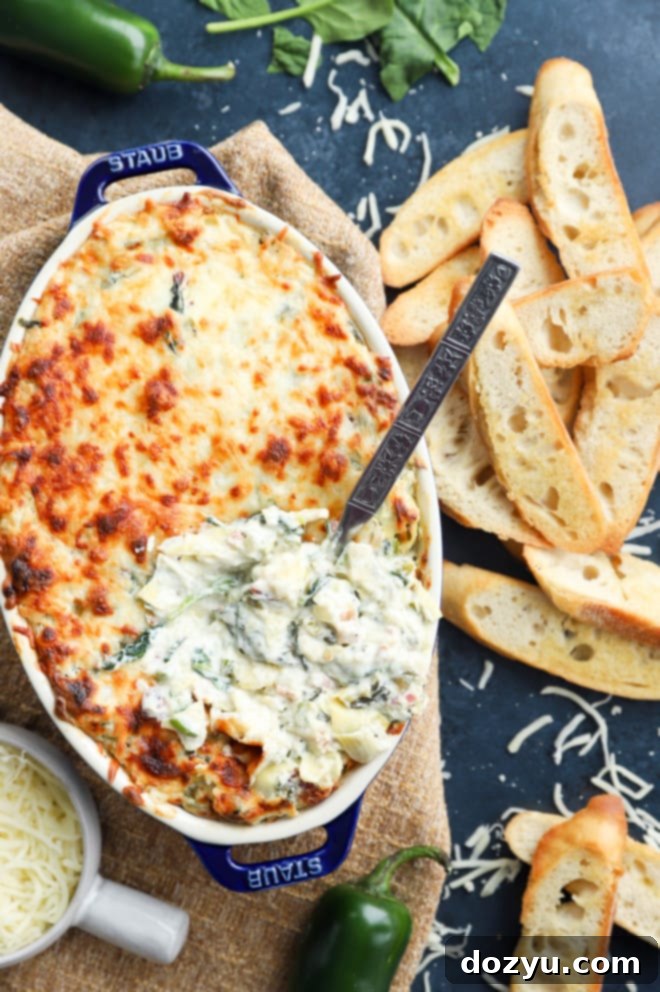 Kickin' Bacon Artichoke Dip 10 Overhead image of bacon jalapeno spinach artichoke baking dish, golden and bubbly.