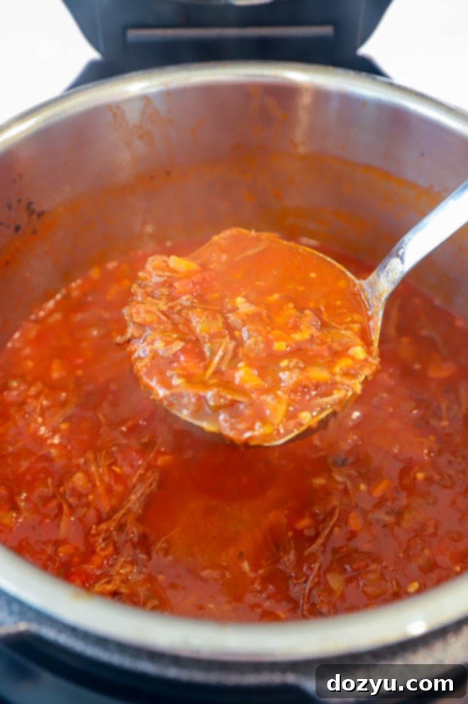 Instant Pot filled with short ribs and ragu sauce, ready for pressure cooking