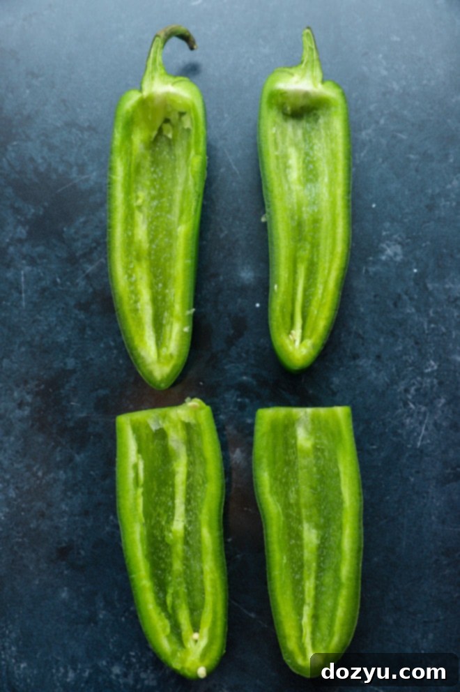 Overhead image of several jalapeño halves, perfectly seeded and ready for further preparation.