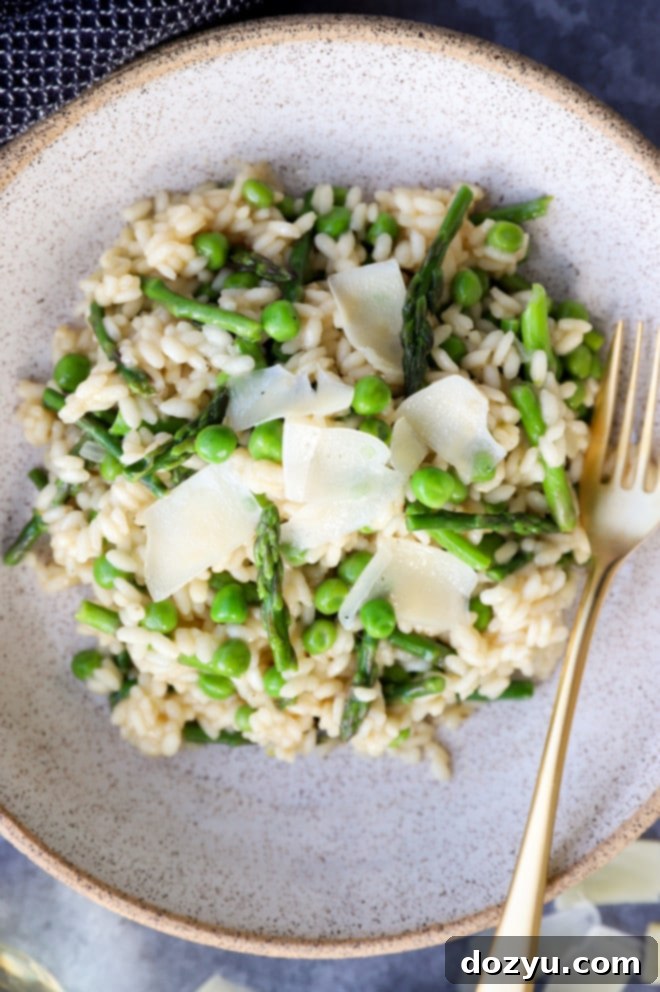 Simple and easy spring risotto recipe featuring fresh asparagus and peas, served in a rustic bowl.