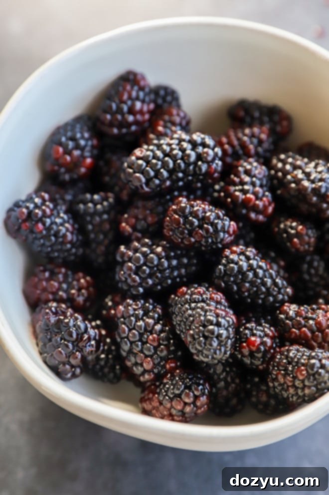 Close-up picture of fresh, ripe blackberries in a rustic ceramic bowl