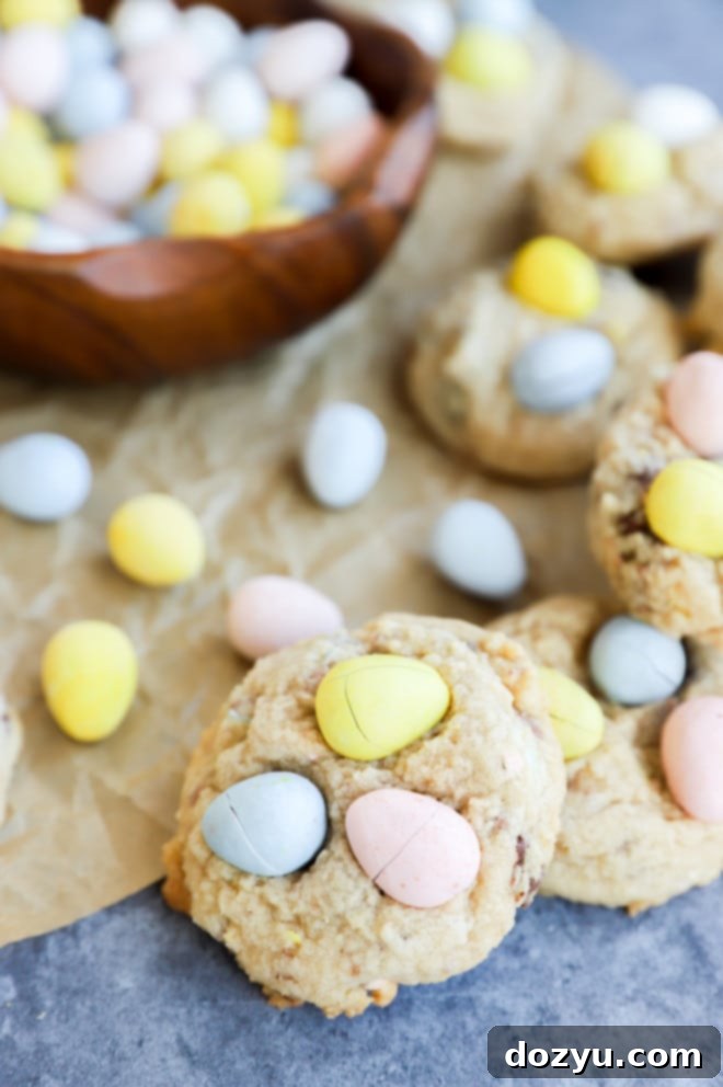 A close-up of freshly baked Mini Eggs Cookies, with their golden-brown edges and vibrant Mini Eggs peeking through.