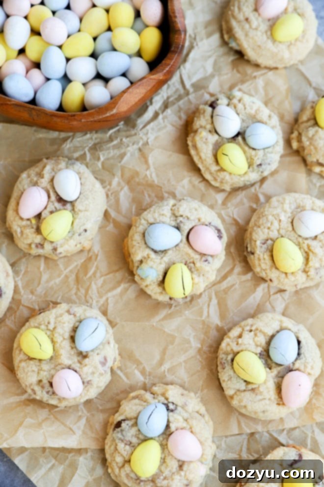 An overhead shot of freshly baked Easter desserts, including Mini Eggs Cookies, cooling on parchment paper.