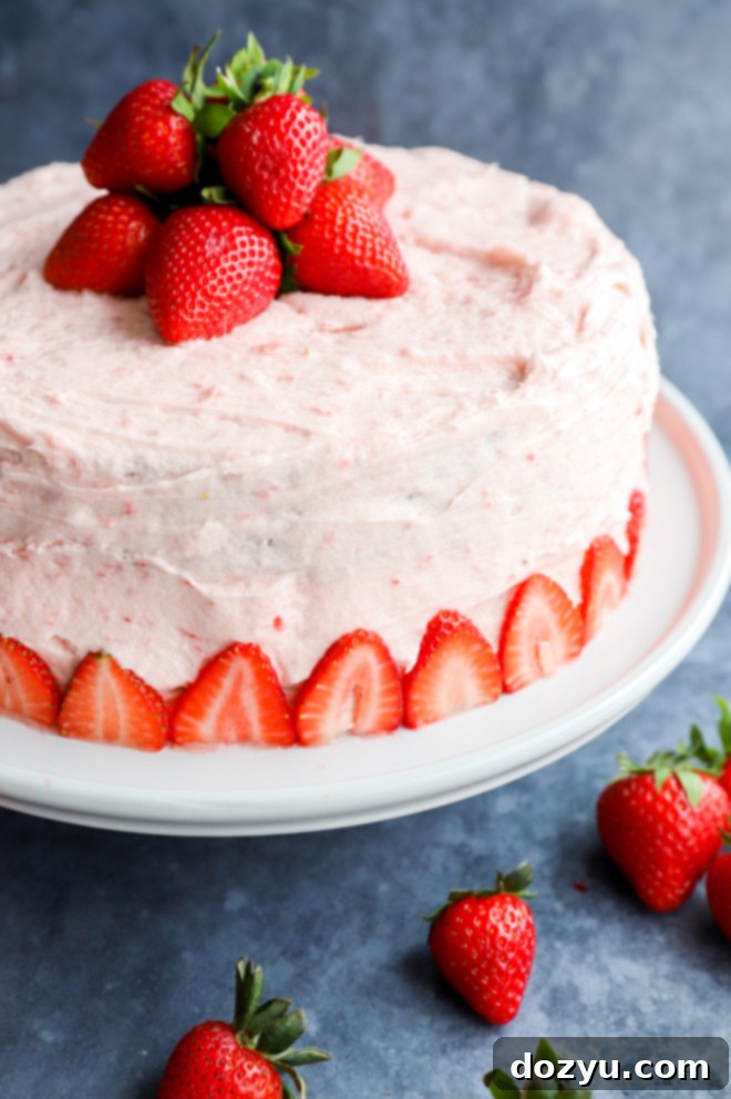 Fresh strawberry buttercream frosting on a rich chocolate cake, garnished with whole strawberries, showcasing a perfect dessert