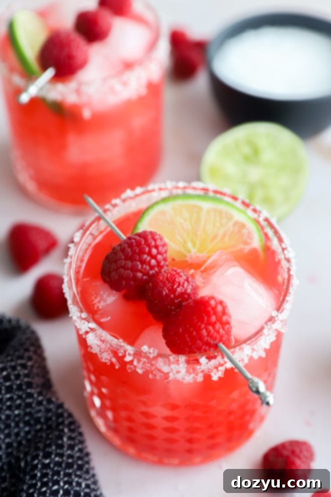 Glasses with red cocktail made out of berries and limes