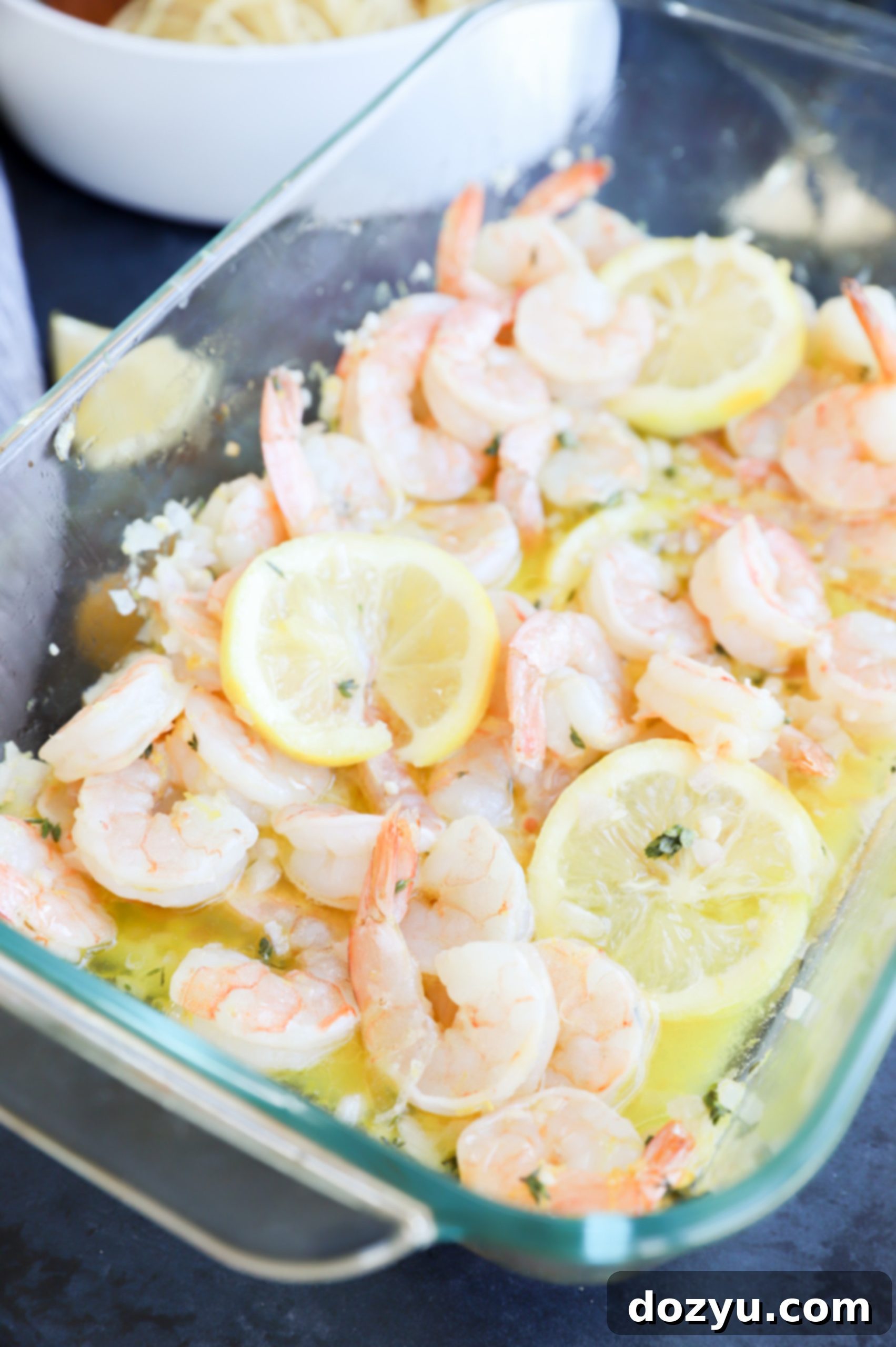 Roasted lemon garlic shrimp with melting butter in baking dish