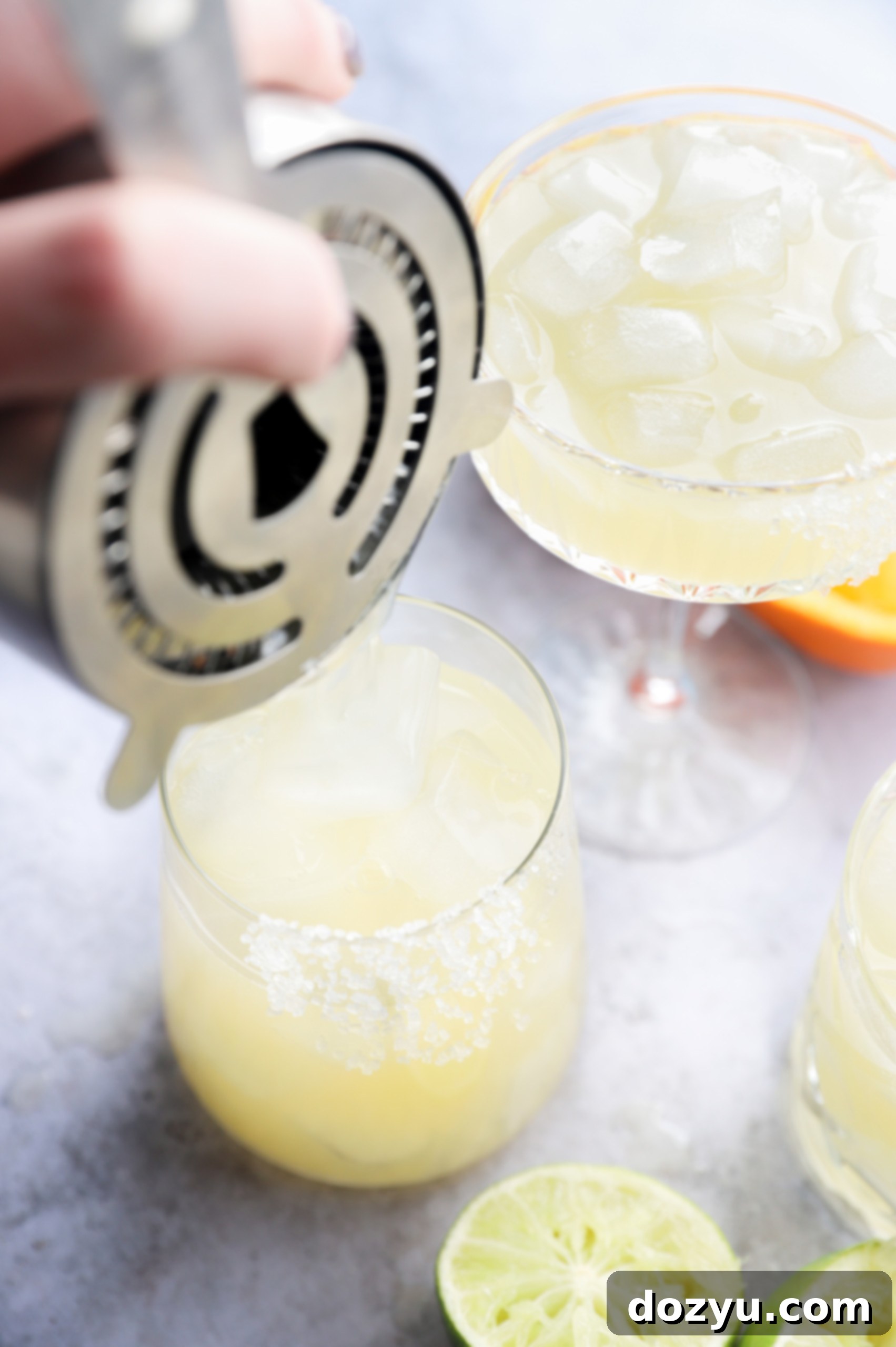 A Texas Margarita being strained into a salt-rimmed glass, ready for enjoyment.