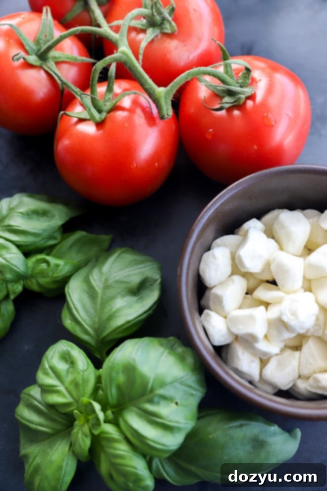 Image of tomatoes, mozzarella, and basil on table