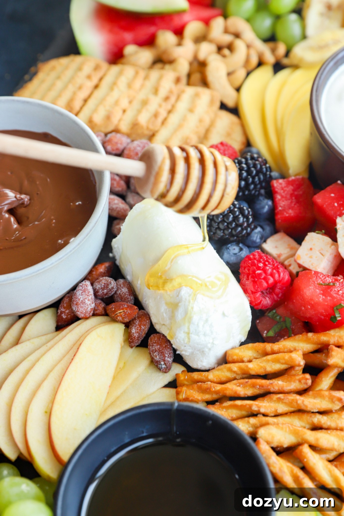Drizzling honey on goat cheese for a cheese platter image
