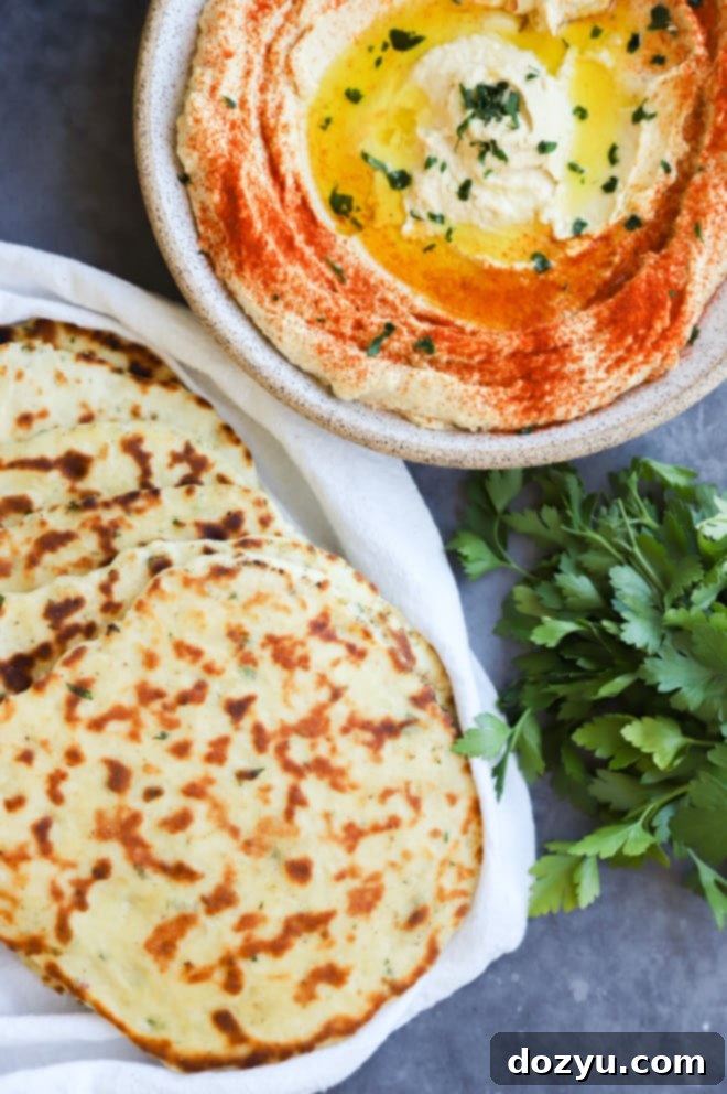 Easy homemade flatbread served with creamy Greek hummus and fresh parsley, perfect for dipping.