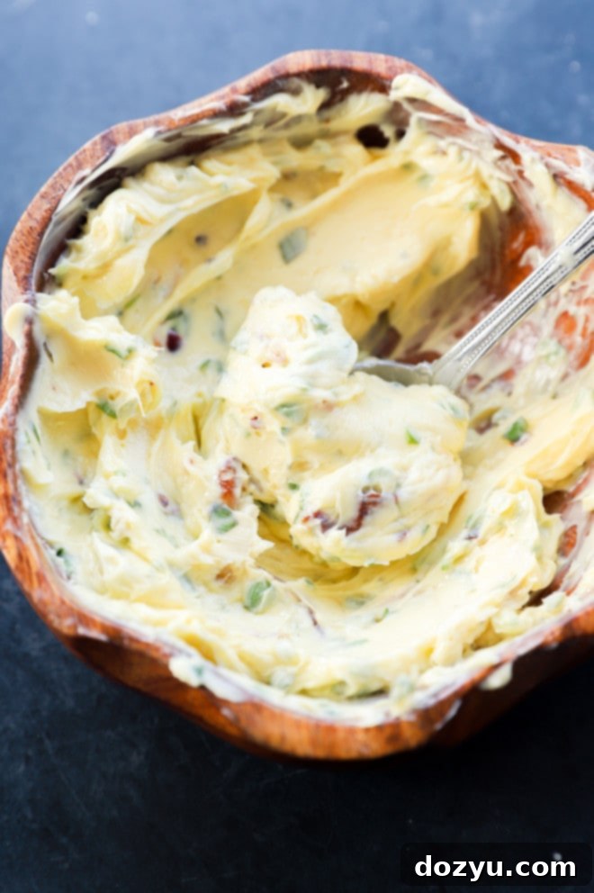 Close-up of roasted garlic butter in a bowl, ready to be spread onto bread.