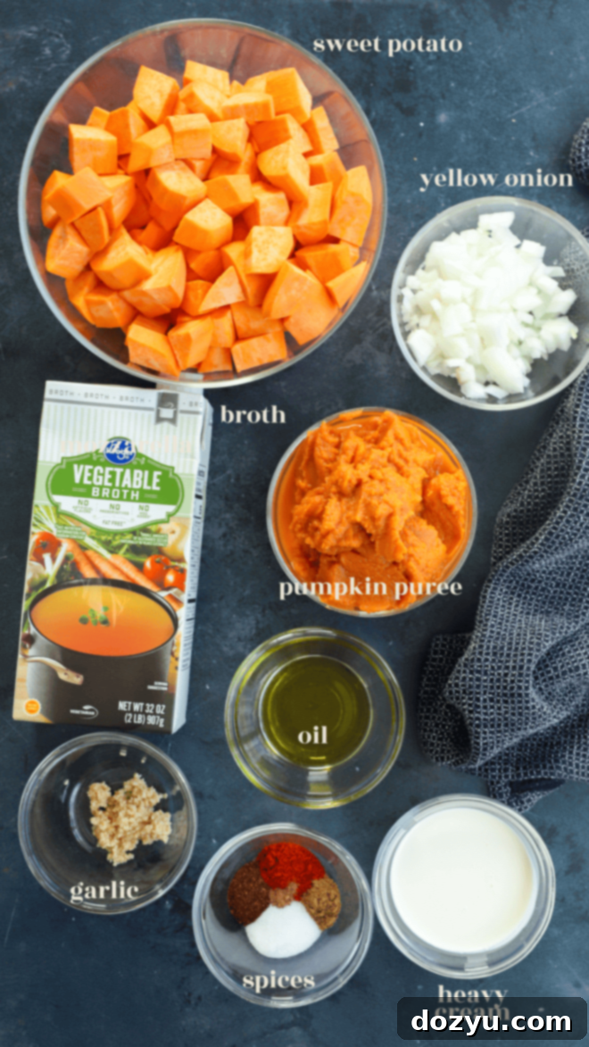Ingredients for creamy pumpkin and sweet potato soup laid out on a wooden board