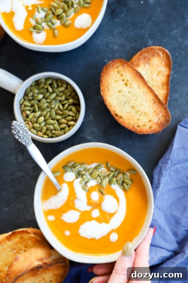 Picture of a comforting fall meal: creamy pumpkin and sweet potato soup with bread and garnishes