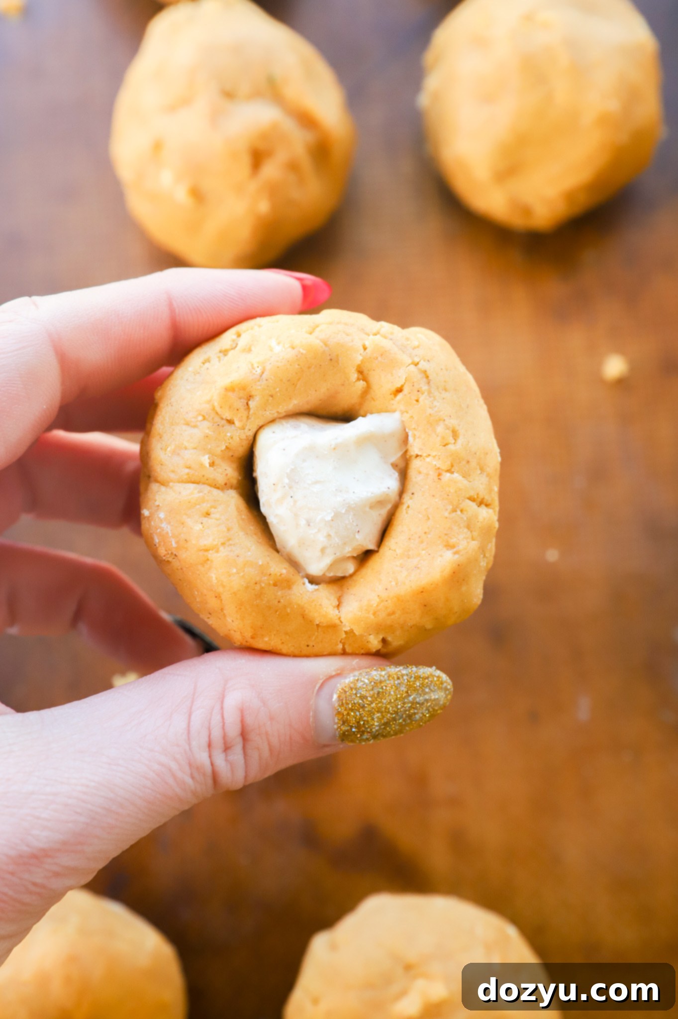 stuffing a pumpkin cookie dough ball with a cheesecake ball