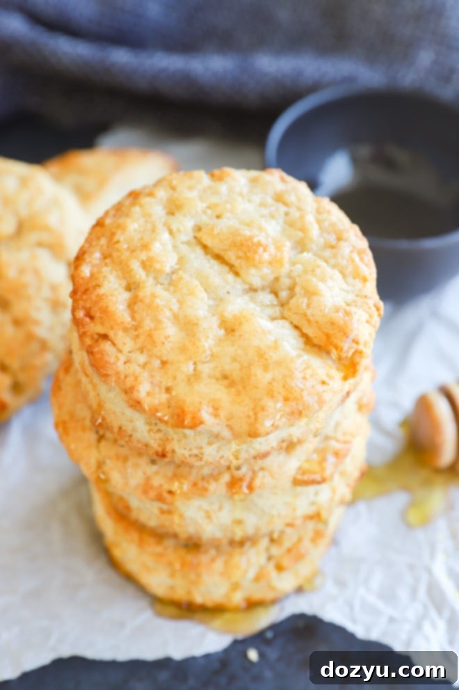 A beautifully arranged stack of golden Honey Butter Biscuits, showcasing their flaky texture.