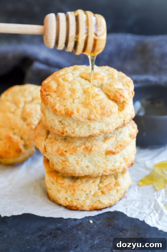 Golden-brown Honey Butter Biscuits being drizzled with additional honey, highlighting their appealing texture.