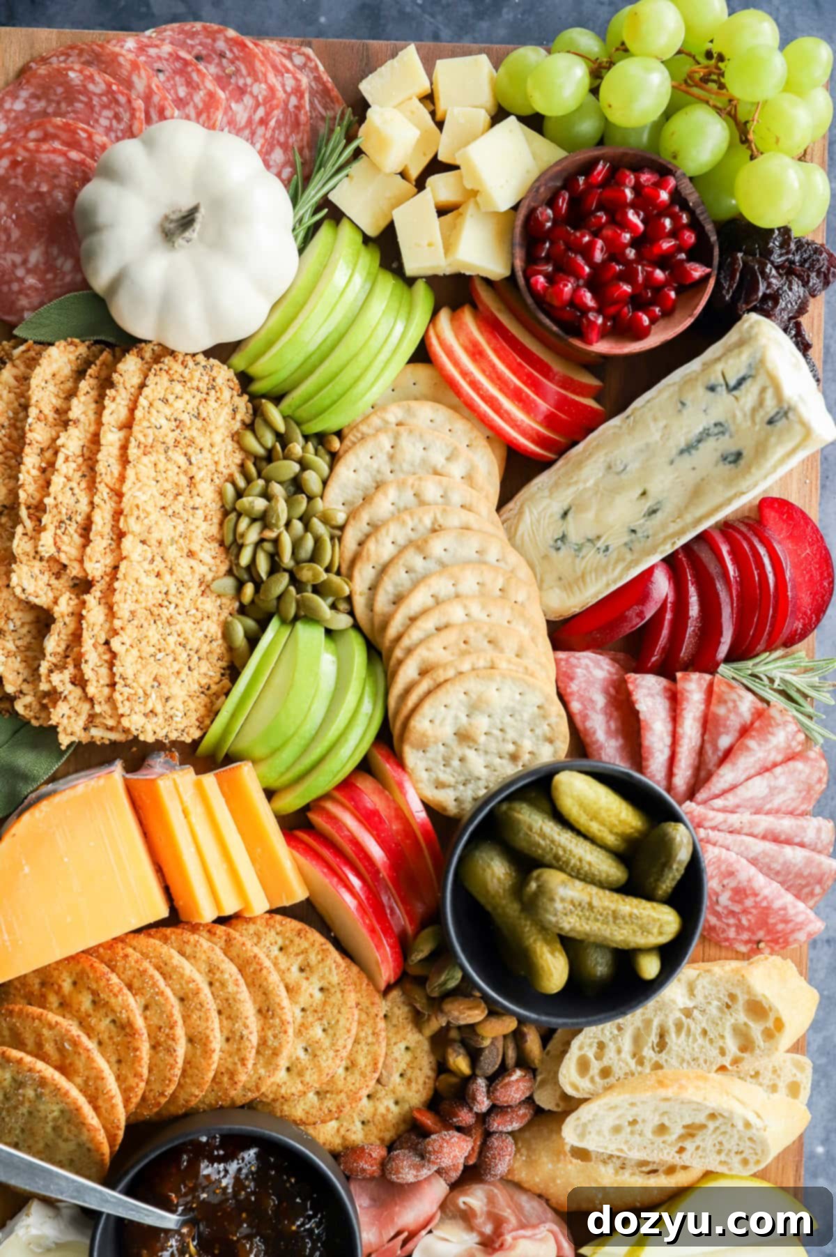 Close-up of a fall charcuterie board with various meats, cheeses, and fresh autumn fruits