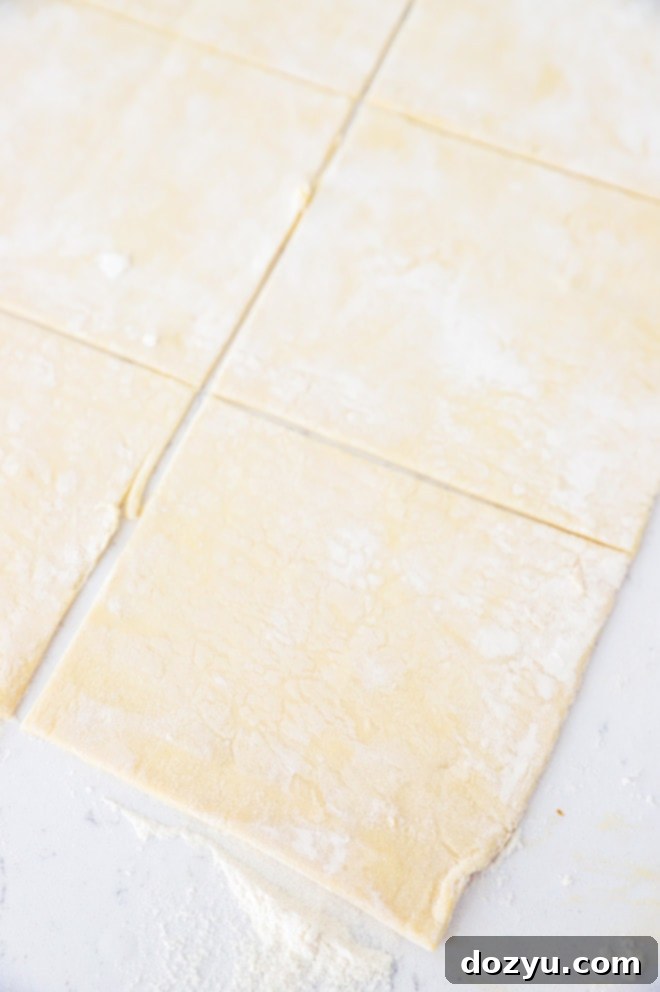 Puff pastry sheet cut into six equal squares for Nutella pies.