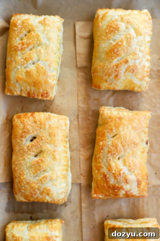 Sweet baked Nutella puff pastry pies on a baking sheet with parchment paper.
