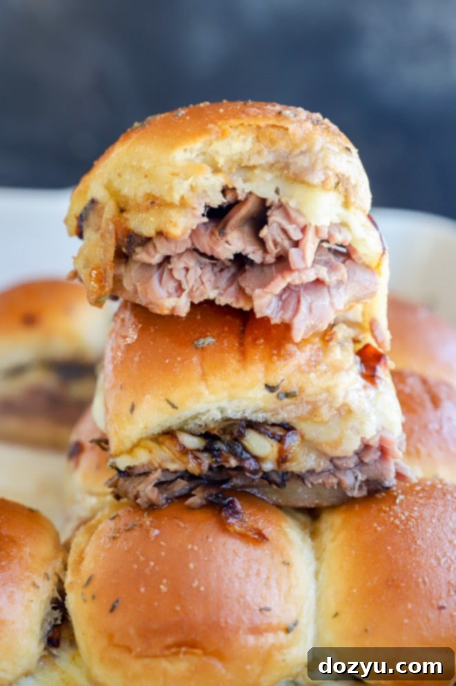 a stack of roast beef sliders, perfectly cooked with melted cheese and golden buns