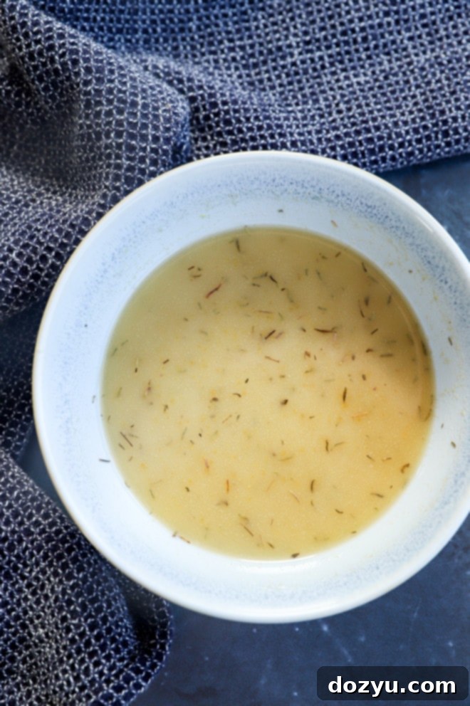a small bowl containing the melted butter mixture with spices and brown sugar, ready to be poured over the sliders