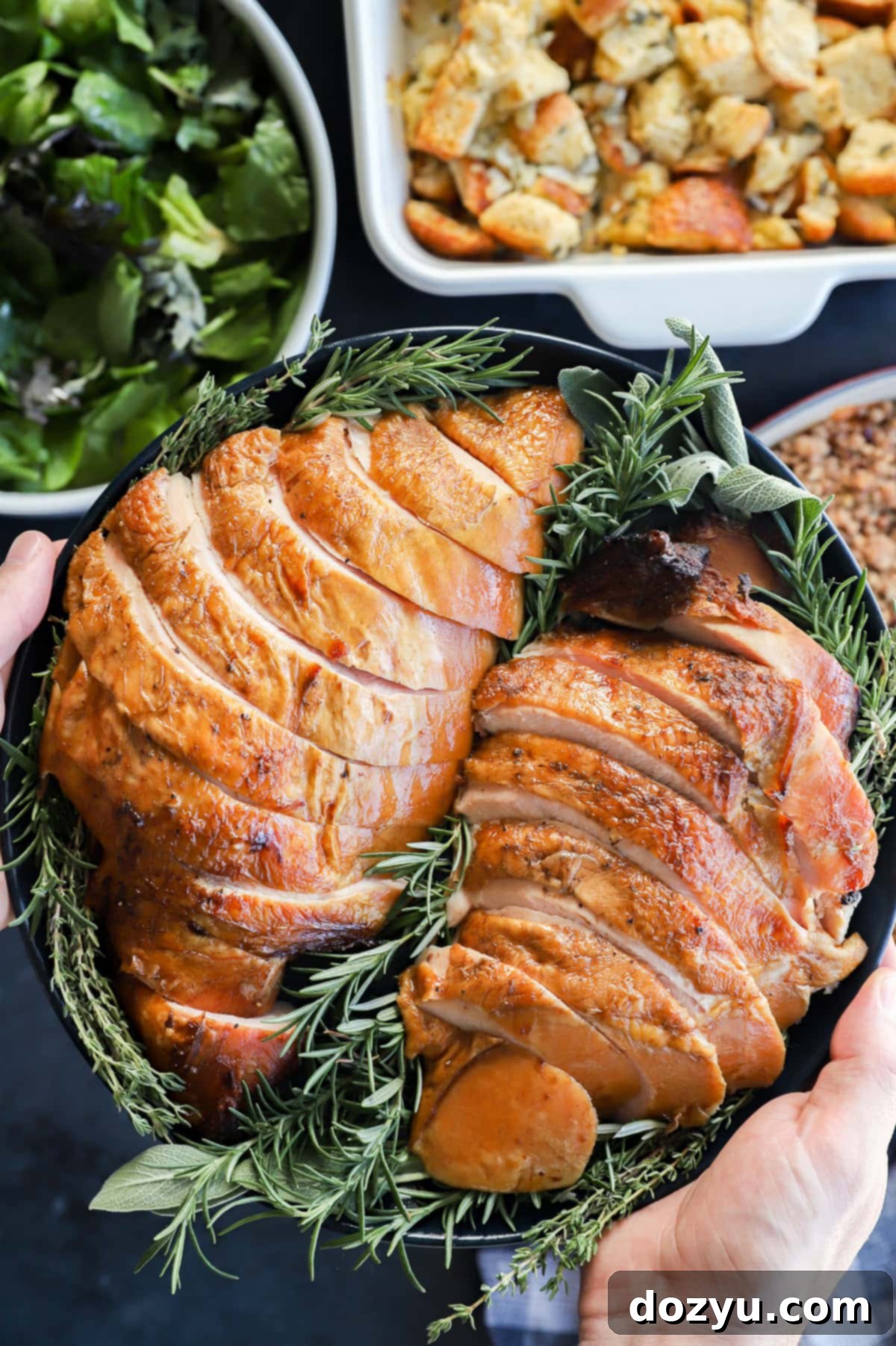 Signature Smoked Turkey Breast 12 holding a plate of sliced meat for the Thanksgiving table