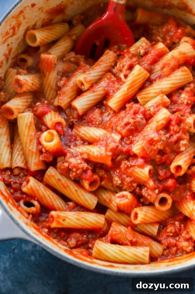 Rigatoni pasta mixed with homemade sauce, ricotta, and mozzarella cheese in a large pot