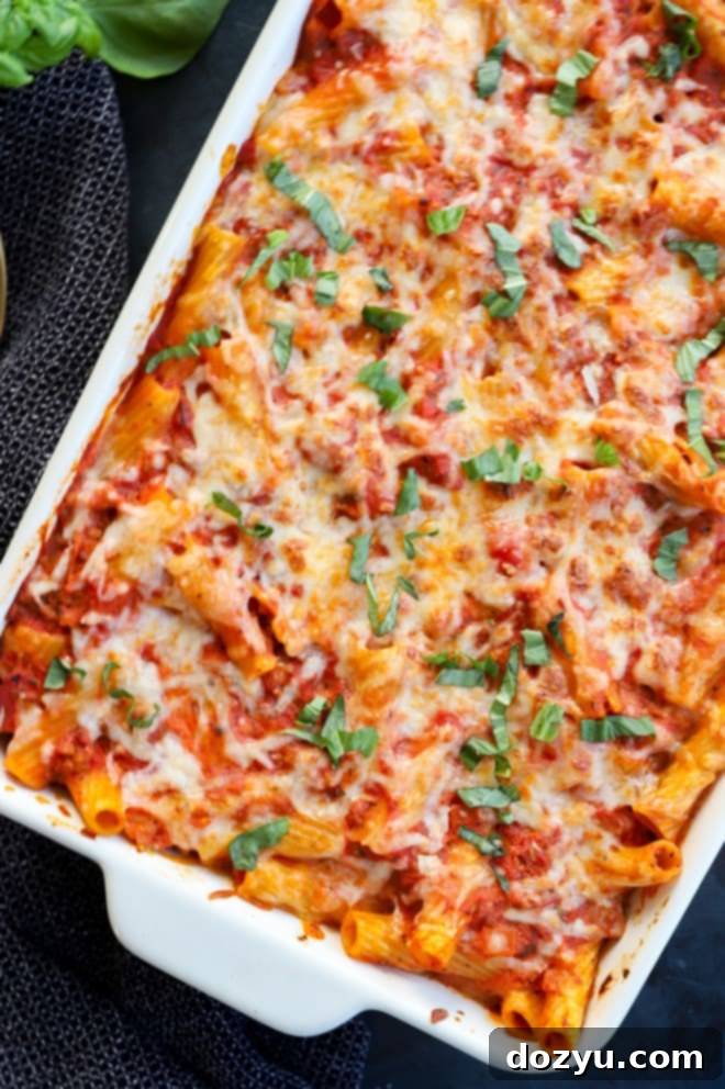 An appetizing close-up image of baked rigatoni al forno in a baking dish, showing the melted cheese and rich sauce
