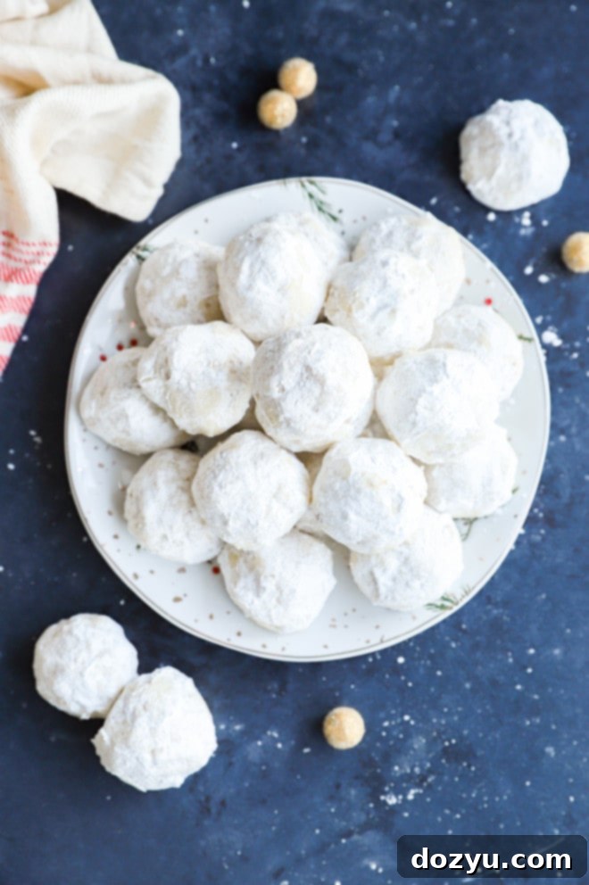 Christmas treats with powdered sugar on a plate in a pile, ready to be enjoyed