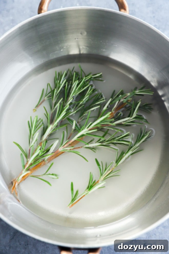 Aromatic Rosemary Nectar 5 Making homemade rosemary simple syrup in a saucepan on the stove