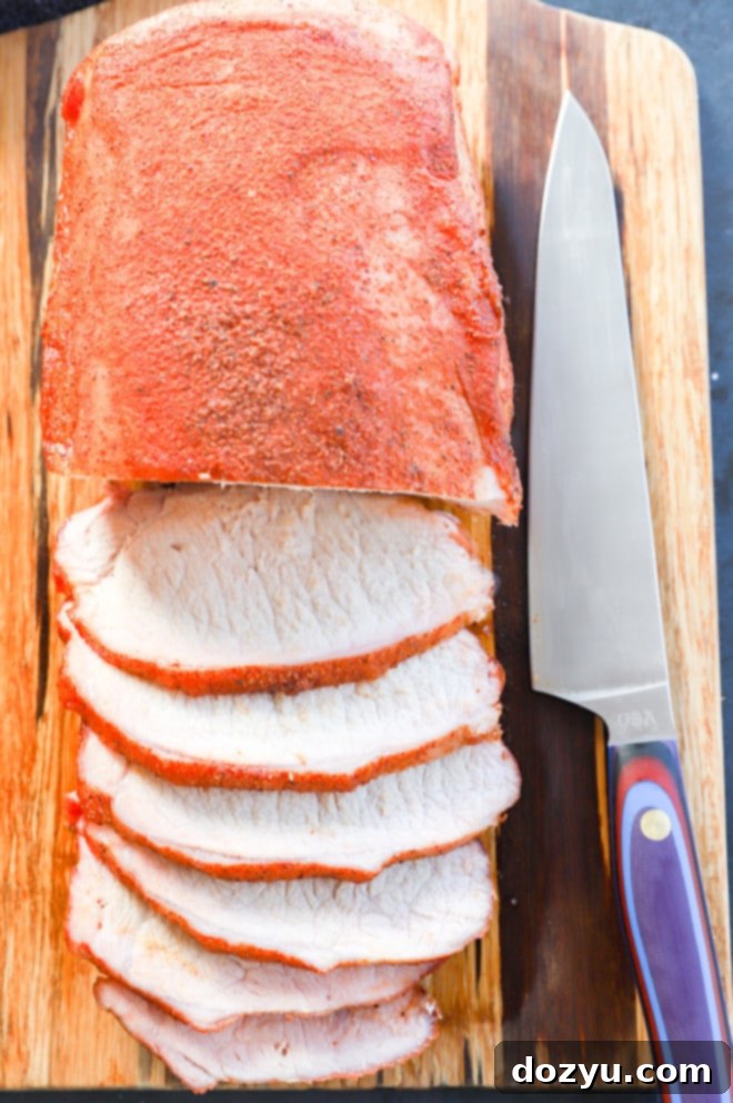 pork loin roast smoked and sliced on cutting board with knife