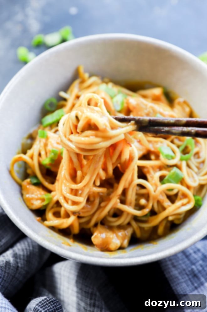 Hearty Golden Curry Udon 8 Chopsticks lifting up noodles from a bowl with chicken
